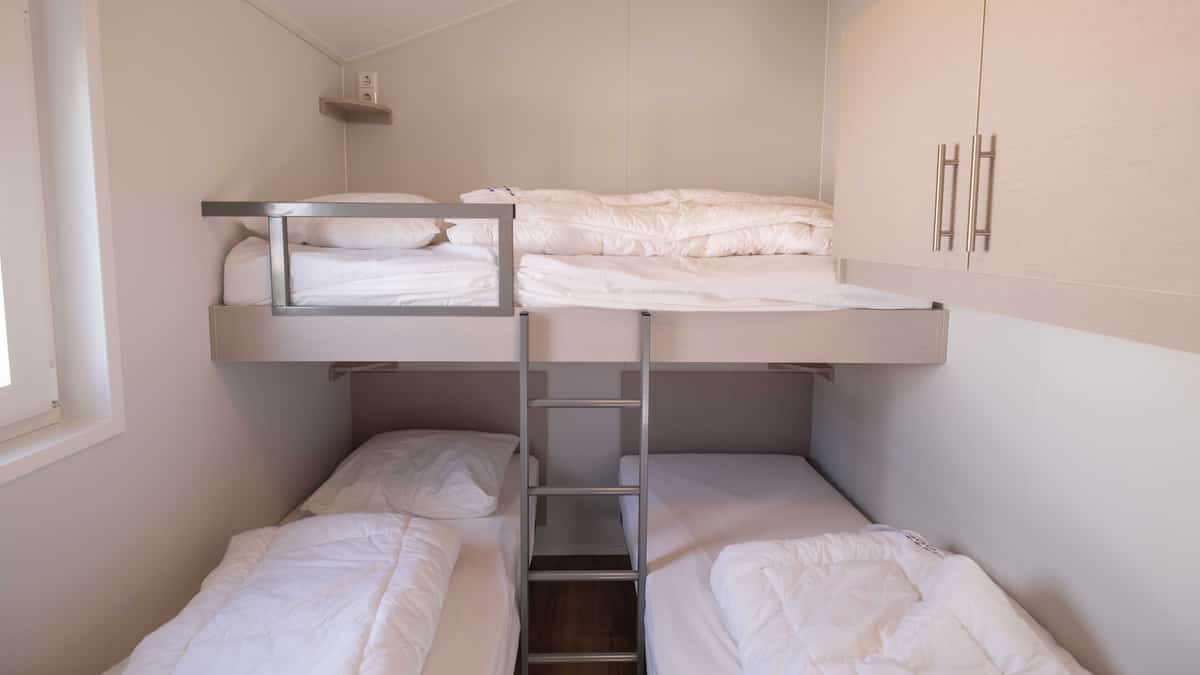 Slaapkamer met eenpersoonsbedden en hoogslaper in Chalet Deluxe Bonte Piet op Camping Cupido