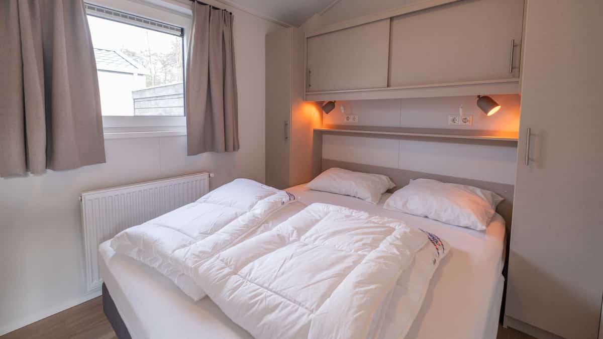 Slaapkamer met tweepersoonsbed in Chalet Deluxe Bonte Piet op Camping Cupido