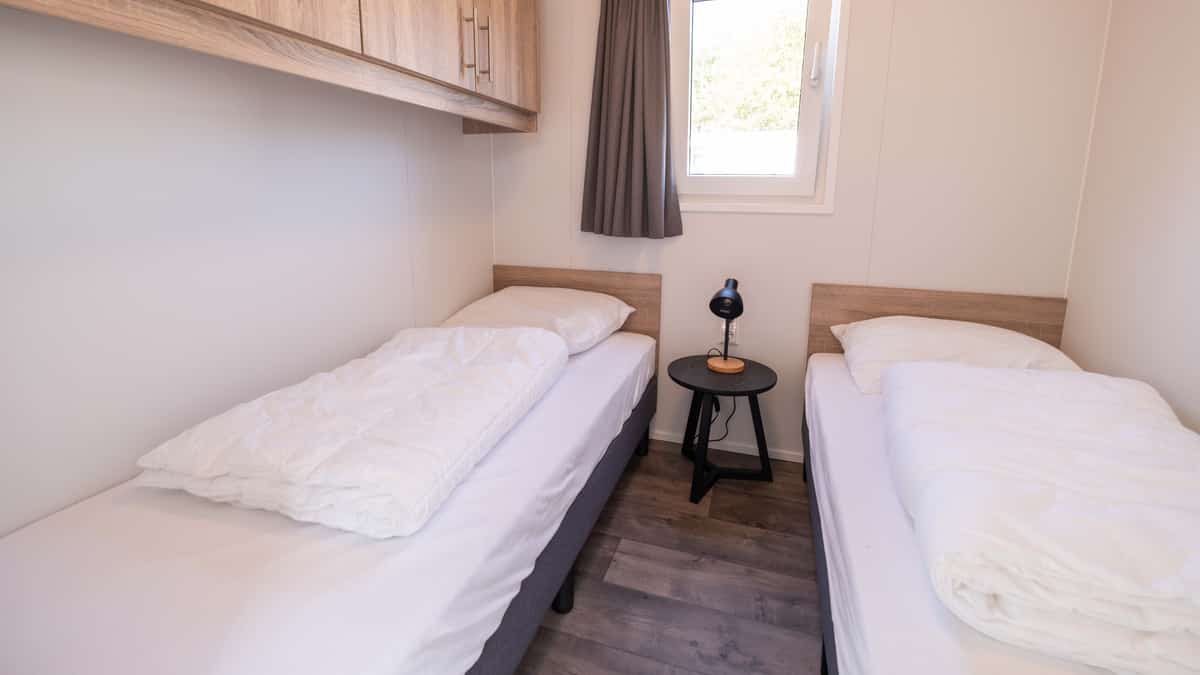 Slaapkamer met twee eenpersoonsbedden in Chalet Deluxe Marcel op Camping Cupido