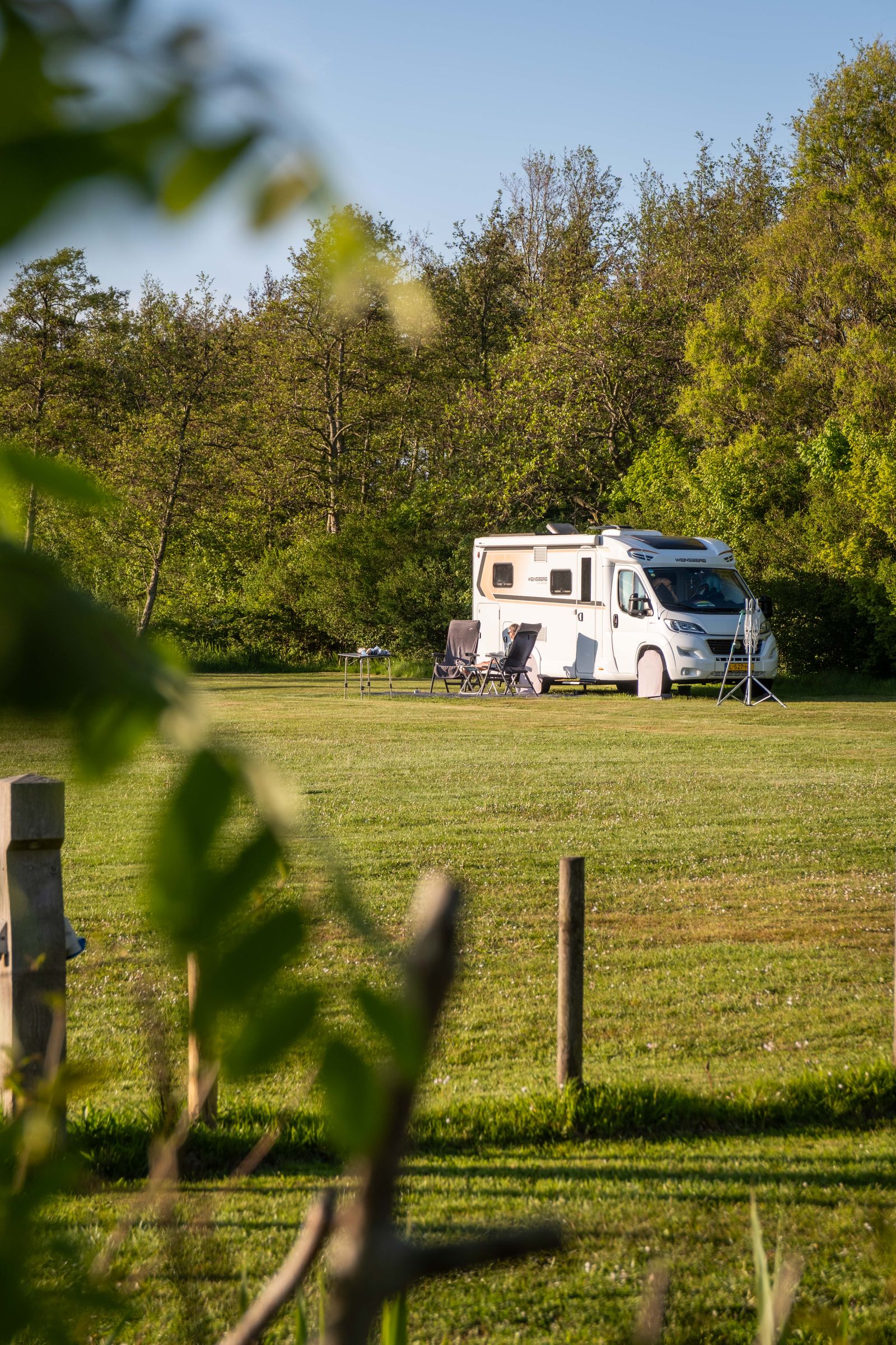 Camper op een kampeerplaats tussen het groen op Camping Cupido