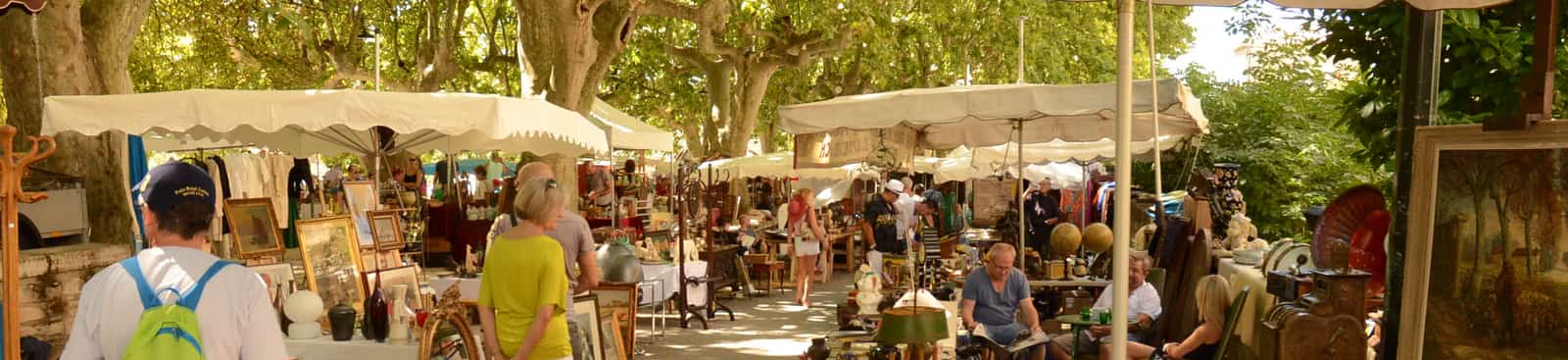 Buitenmarkt met antiek en schilderijen onder parasols