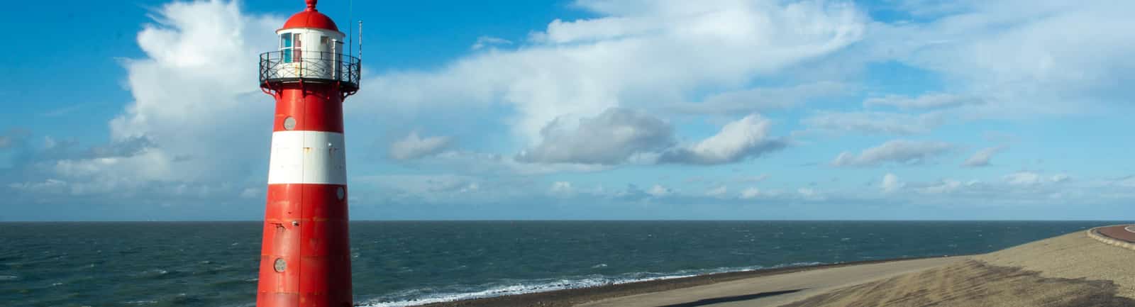 Rode en witte vuurtoren aan de kust