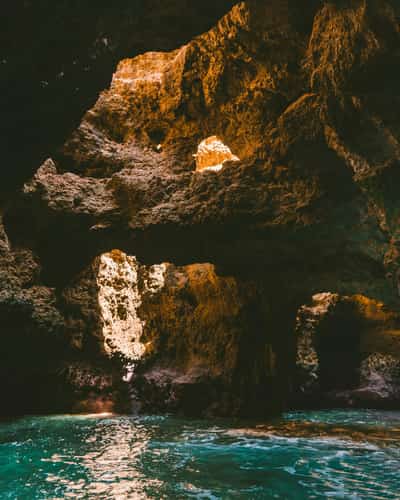 Rotsgrot met turquoise water