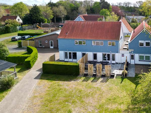 Blauwe gebouwen met rode daken, terrassen en groen gazon