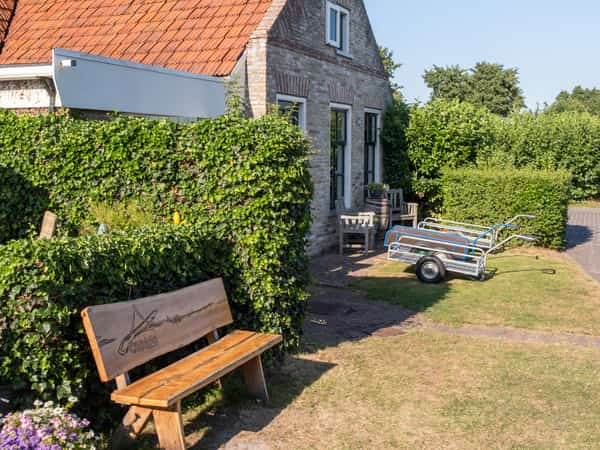 Wit huisje met bankje op Camping Cupido
