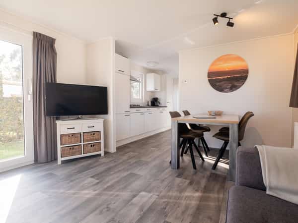 Woonkamer met eethoek in Chalet Deluxe Duinroosje op Camping Cupido