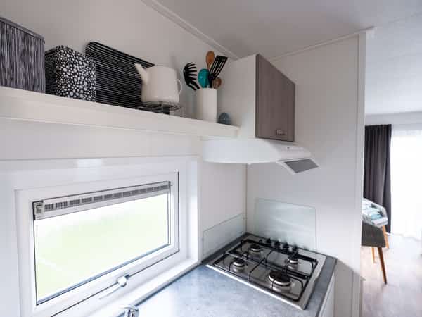 Keuken met open planken, opbergdozen en een gasfornuis