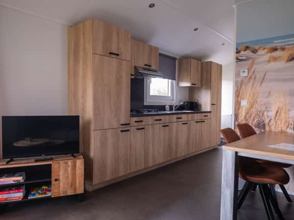 Woonkamer met tv en eethoek in Chalet Deluxe Kluut op Camping Cupido