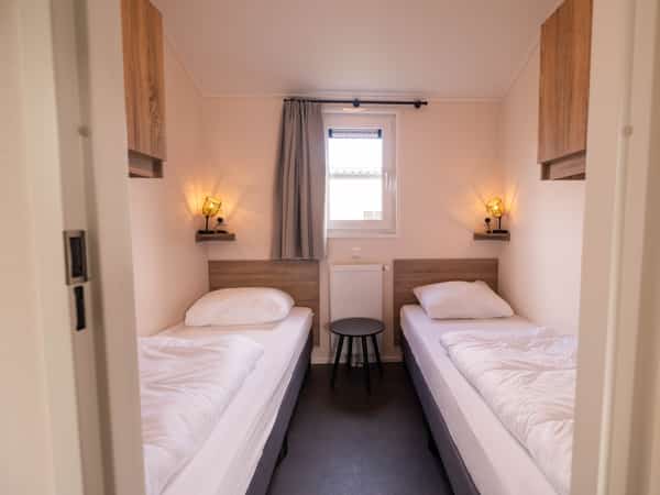Tweede slaapkamer met eenpersoonsbedden in Chalet Deluxe Kluut op Camping Cupido