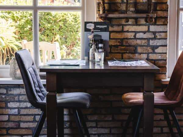 Tafel bij het raam in Eetcafé De Millem op Camping Cupido