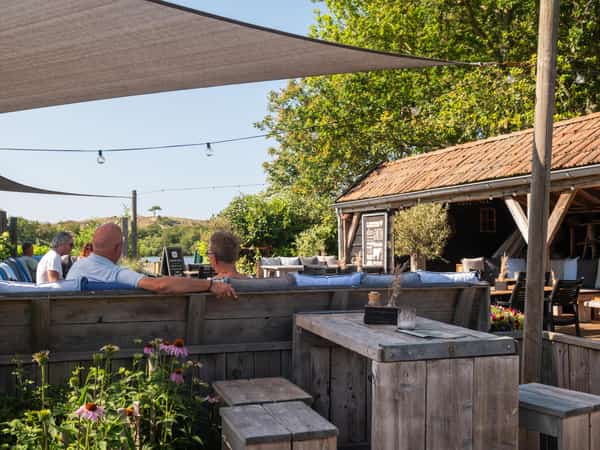 Gasten op het terras van Eetcafé De Millem op Camping Cupido
