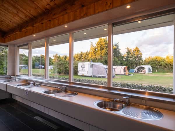 Afwasplek met uitzicht over het kampeerveld van Camping Cupido