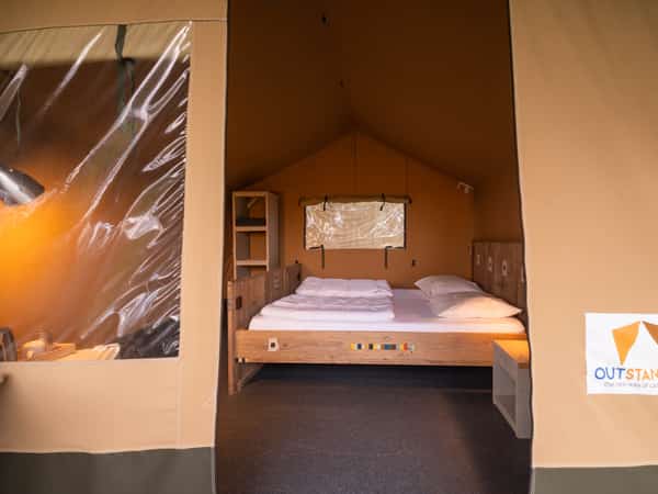 Slaapkamer met tweepersoonsbed in een 2-persoons safaritent op Camping Cupido