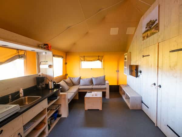 Houten interieur met kitchenette, bank en kleine eettafel
