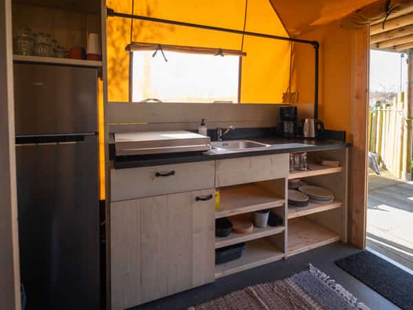 Keuken met koelkast in een safaritent op Camping Cupido