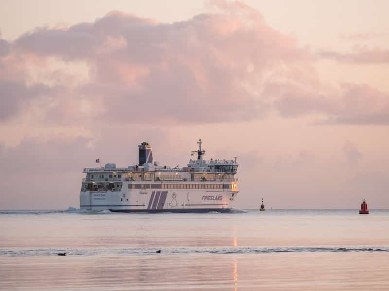 Veerboot Friesland op zee onder roze wolkenlucht bij schemering